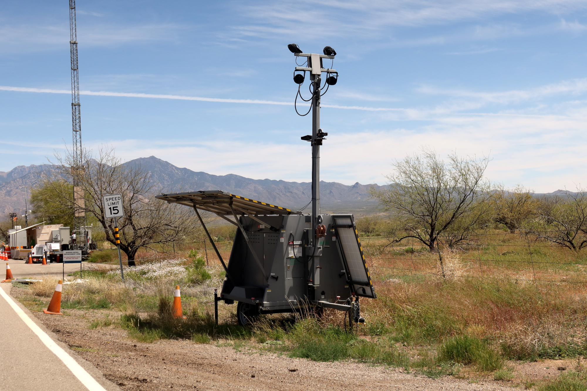 A trailer with a pole with mounted ALPR cameras in the desert.